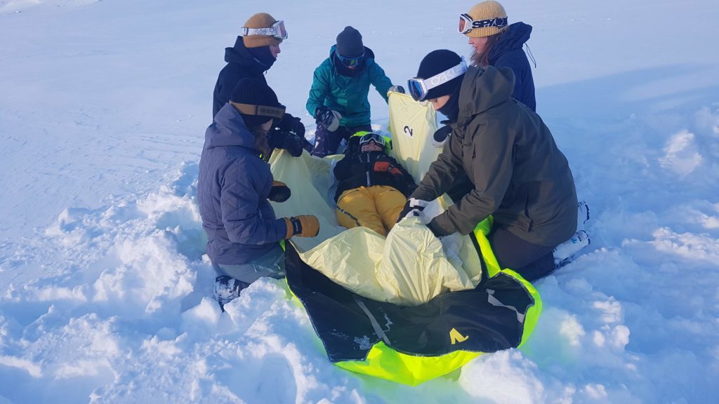 Casualty being wrapped in Thermosaver in snow during training